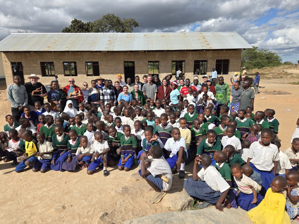 Mission team, students, and villagers outside the schoolhouse built through Brotherhood mission trips.